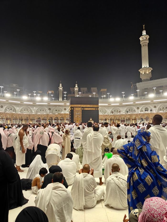 Thousands gather for prayers at the Kaaba in Mecca during nighttime pilgrimage.